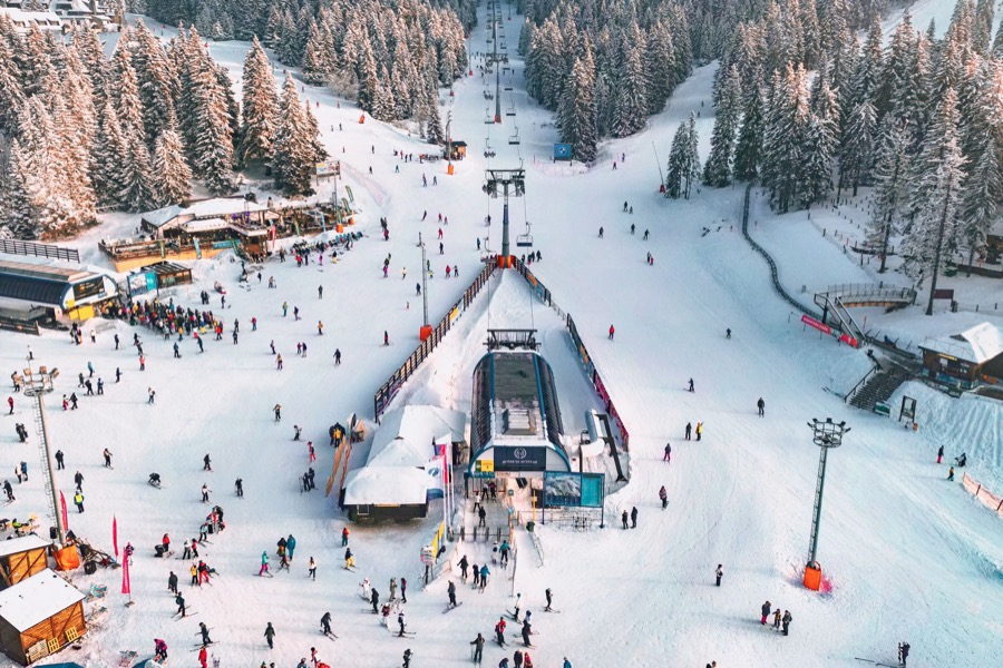 Le front de neige d’une station, remontée mécanique et skieurs.